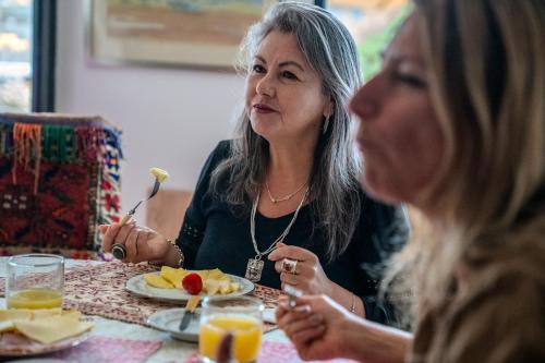 two women sitting at a table eating food at Hotel Boutique Aldea del Mar in Pichilemu