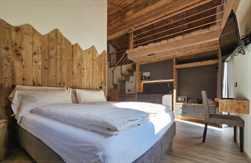 a bedroom with a large bed and a desk at Agriturismo Bosco d'oro Livigno in Livigno