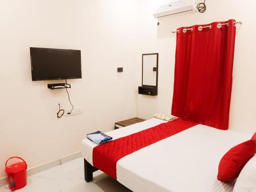 a bedroom with a bed with a red curtain at Rudra Elite in Rāmeswaram