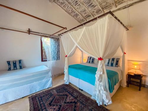 1 dormitorio con 2 camas y mosquitera en Pousada San Antonio Praia, en Caraíva