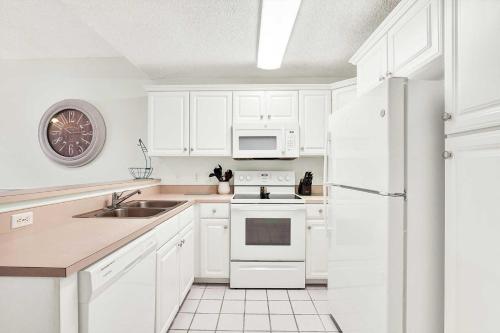 a white kitchen with a sink and a refrigerator at Beach Point Villas Unit E in Tybee Island