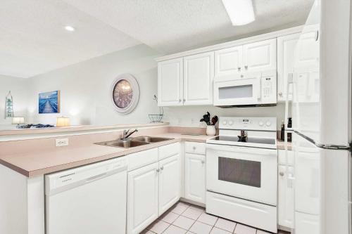 a white kitchen with a sink and a refrigerator at Beach Point Villas Unit E in Tybee Island