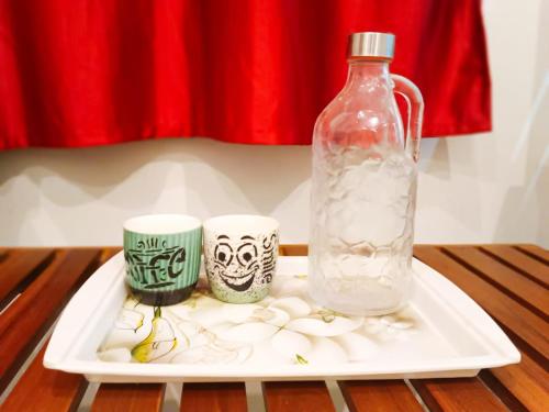 a tray with a bottle and two cups on a table at Rudra Elite in Rāmeswaram