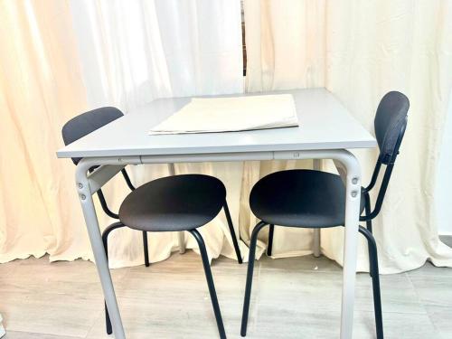 a table with two chairs and a paper on it at Villa Olímpica Doble Vía in Marilópez