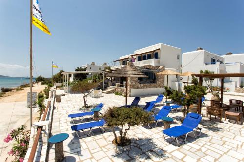 a group of blue chairs on a patio near the beach at Theologos Beach in Antiparos Town
