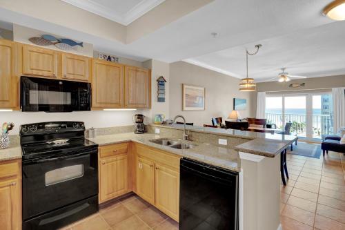 a kitchen with wooden cabinets and a black appliances at Crystal Tower 508 by Vacation Homes Collection in Gulf Shores
