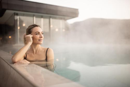 a woman is sitting in a bath tub at Lake Spa Hotel SEELEITEN in Caldaro