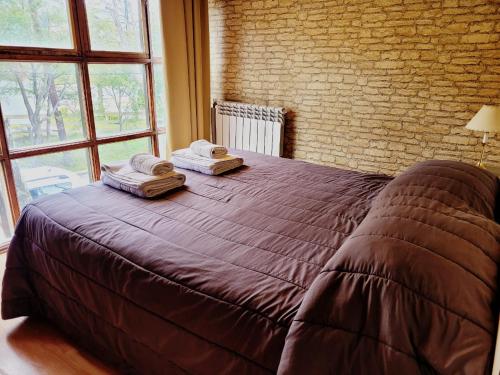 a bedroom with a large bed with two towels on it at Morada de los Legui in Ushuaia
