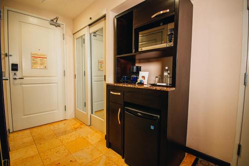 a kitchen with a black counter and a microwave at Hilton Garden Inn Tuxtla Gutierrez in Tuxtla Gutiérrez