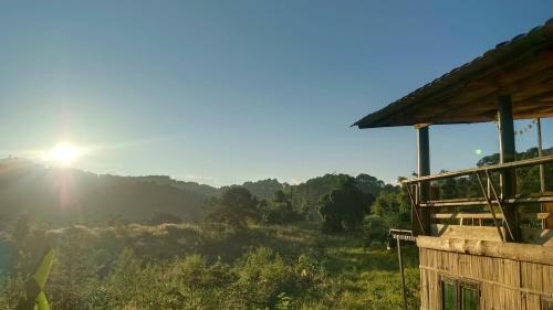 a view of the sun setting from a cabin at ไร่นิธิสุนทร nithisoonthon farmstay in Mae Hong Son