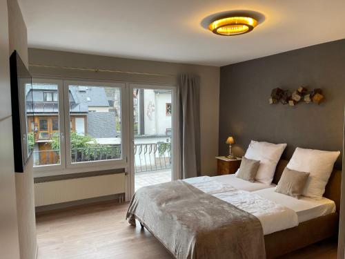 a bedroom with a bed and a large window at Ferienhaus Mosel-Wohnen l in Bruttig-Fankel