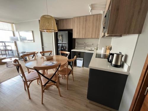 a kitchen and dining room with a table and chairs at Departamento Nuevo a pasos del centro in Pucón