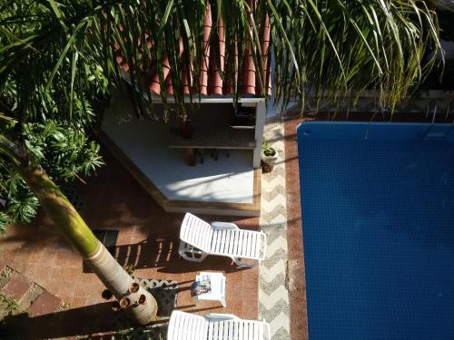 an overhead view of two white chairs and a pool at ApartHotel Maison Suisse in Asuncion