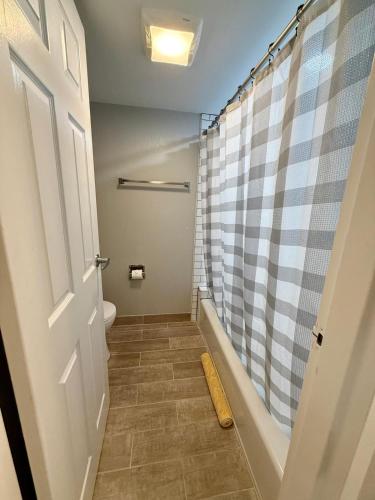a bathroom with a shower and a toilet at Aksarben Gem near UNO in Omaha
