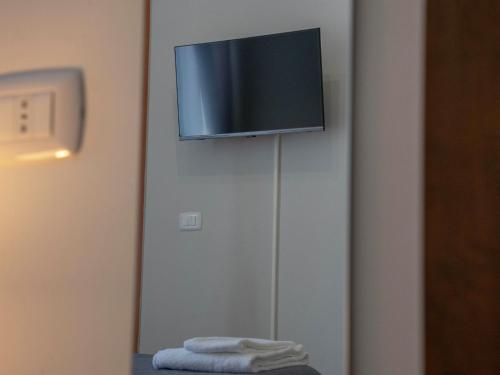a flat screen tv hanging on a wall at F.A.M. ROOMS in Ciampino