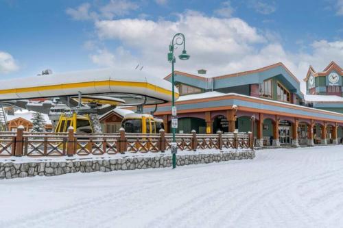a building with a train station in the snow at Winter Escape On Perfection - Ski In Out, Pool & Hot Tub in Big White