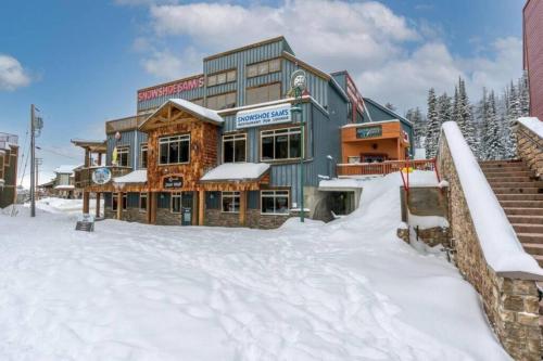 a large building in the snow in front at Winter Escape On Perfection - Ski In Out, Pool & Hot Tub in Big White