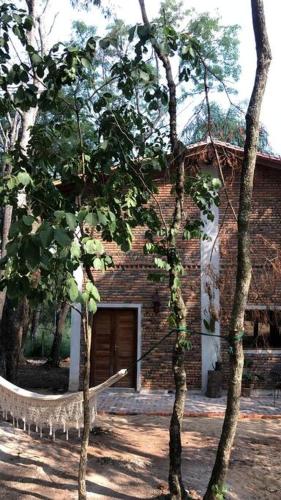 a brick building with a door and some trees at Casa Cabaña en San Bernardino in San Bernardino