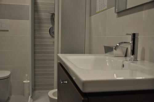 a white bathroom with a sink and a toilet at Millaenya Inn in Entratico
