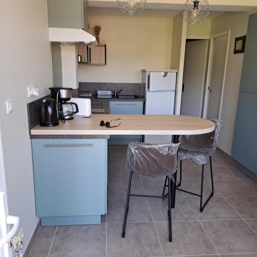 une cuisine avec une table en bois et deux chaises dans l'établissement ARC EN ciel t2 ouest, à Gréoux-les-Bains