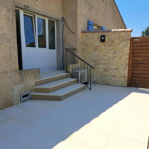 une maison avec une porte blanche et quelques marches dans l'établissement ARC EN ciel t2 ouest, à Gréoux-les-Bains