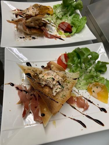 two white plates with food on them with salad at La Locomotive in Issoudun