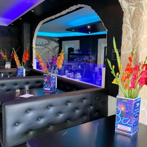 a bar with vases of flowers on a table at La Locomotive in Issoudun