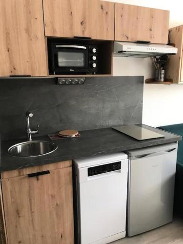 une cuisine avec un évier et un micro-ondes dans l'établissement Résidence Vanoise - VAL THORENS STUDIO 2 PERS AU PIED DES PISTES ET AU COEUR DE LA STATION MAE-7804, à Val Thorens