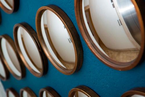 a bunch of wooden mirrors on a blue wall at Doña Urraca Hotel & Spa in Querétaro