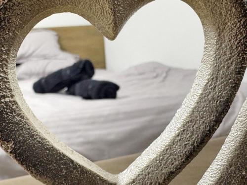 a heart shaped mirror in front of a bed at BDR residence in Craiova