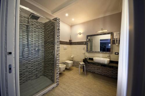 uma casa de banho com um chuveiro, um WC e um lavatório. em La Corte del Geco em Crotone