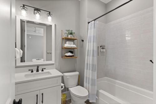 a white bathroom with a sink and a toilet and a shower at Hook, Wine & Sinker - 20 Couper Place in Mallory Park