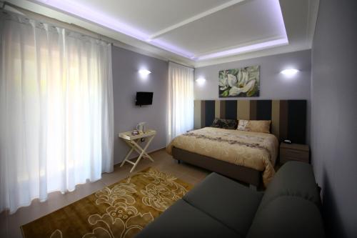 a bedroom with a bed and a couch in it at La Corte del Geco in Crotone