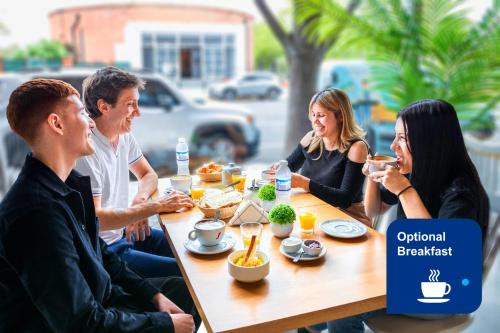 un grupo de personas sentadas alrededor de una mesa comiendo comida en Modern Apartments in Puerto Madero en Buenos Aires