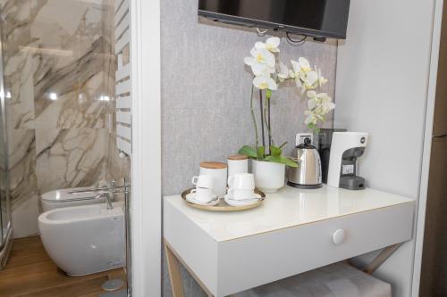 a bathroom with a counter with cups and flowers on it at La Genziana in Rome