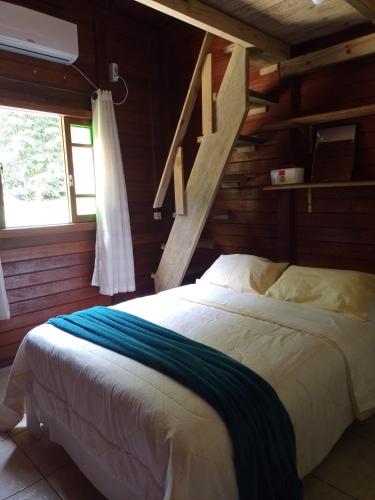 a bedroom with a bed in a log cabin at Sítio com piscina em Caldas da Imperatriz in Santo Amaro da Imperatriz