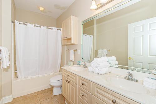 a bathroom with a sink and a toilet and a mirror at Ground Floor 3 Bedroom Condo! Magnolia Pointe 105! Sleeps 6 guests in Myrtle Beach