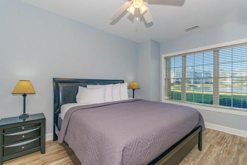 a bedroom with a bed with a ceiling fan and a window at Ground Floor 3 Bedroom Condo! Magnolia Pointe 105! Sleeps 6 guests in Myrtle Beach
