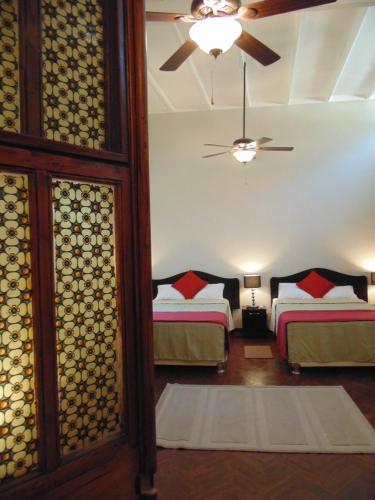 a bedroom with two beds and a ceiling fan at Casa Mendoza in Sullana