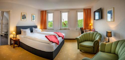 a bedroom with a bed and a couch and a chair at Böhler's Landgasthaus in Bad Driburg