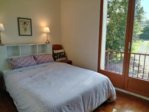 une chambre avec un lit et une grande fenêtre dans l'établissement Maisonette next to woodland, à Masseret