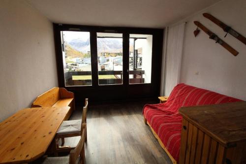 un salon avec un canapé rouge et une table dans l'établissement Résidence Home Club 1 - studio soigné et confortable MAE-3776, à Tignes