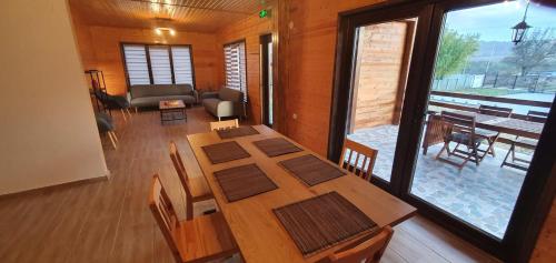 een eetkamer met een tafel en een woonkamer bij Pensiunea agroturistica The Hive 