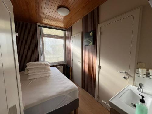 a small bedroom with a bed and a sink at SWEET HOME in Blankenberge