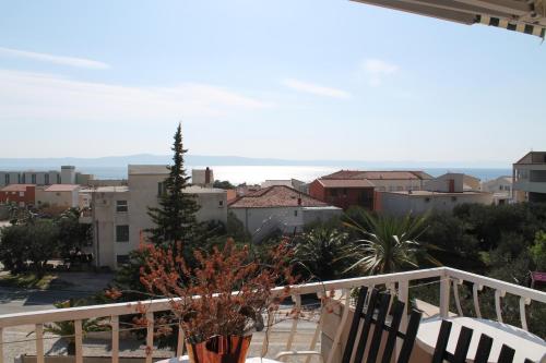 a balcony with chairs and a view of a city at Villa Bougenvilia Tomas in Tučepi