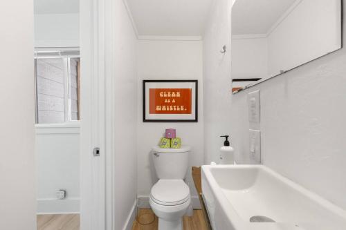 a white bathroom with a toilet and a bath tub at Hot Tub 4 Baths Montana Themed Bike To Downtown in Livingston