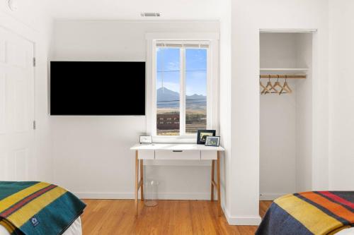 a white bedroom with a desk and a window at Hot Tub 4 Baths Montana Themed Bike To Downtown in Livingston