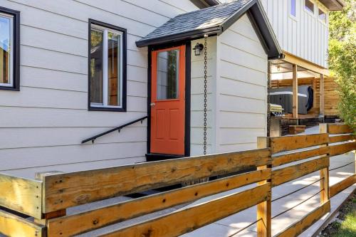 a tiny house with a red door on a white house at Hot Tub 4 Baths Montana Themed Bike To Downtown in Livingston