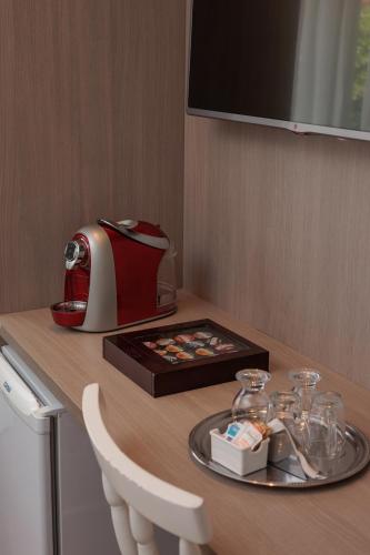 a table with a toaster and a tray with glasses on it at Pousada Naala Gramado in Gramado