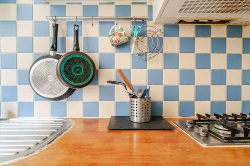 un comptoir de cuisine avec des casseroles et des poêles sur le mur dans l'établissement Appartement Porte De Clichy, à Clichy